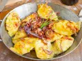 Herzhafte pierogi ruskie, goldgelb und dampfend, garniert mit knusprigem Speck, karamellisierten Zwiebeln und frischem Schnittlauch.