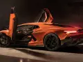 Pomarańczowy Lamborghini Revuelto z otwartymi drzwiami, ukazujący sportowe wnętrze i agresywną sylwetkę.