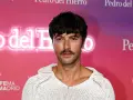 Hombre con un estiloso bigote, perfecto para Movember, luce un jersey blanco de punto.