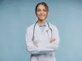 Uśmiechnięta lekarka w białym kitlu ze stetoskopem, zastanawia się, ile zarabia psychiatra.
