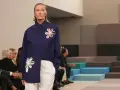 Modella con camicia blu Fendi e pantaloni bianchi, un'icona di stile che racconta la sua storia.
