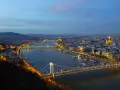 Vista nocturna de Budapest con el río Danubio y sus puentes iluminados, creando un paisaje urbano mágico.