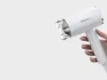 Biała suszarka Warmtec trzymana w dłoni.