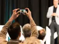 Jemand filmt eine Präsentation mit dem Handy, um ein Musikvideo zu drehen.