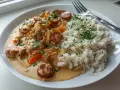 En tallrik med krämig korv stroganoff och fluffigt ris, toppat med färsk persilja. En klassisk svensk rätt som värmer själen.
