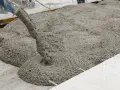 Calcestruzzo fresco versato da una pompa. La corretta tabella dosaggio calcestruzzo garantisce la qualità.