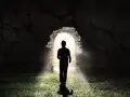 Ein Mann im Schatten tritt aus einer Höhle ins Licht. LK 21.