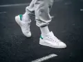 Un paio di sneakers bianche con dettagli verdi, simbolo di stile e comfort. Il loro significato va oltre la moda, rappresentando libertà di movimento.