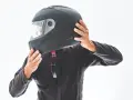 Persona indossa un casco integrale nero, pronto per un giro in moto.