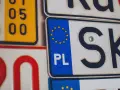 Kolekcja tablic rejestracyjnych, w tym polska z symbolem UE i oznaczeniem PL.