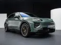 Zielony elektryczny Porsche Macan na ciemnym tle.