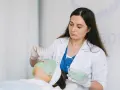Dermatolog nakłada zieloną maskę na twarz pacjentki.