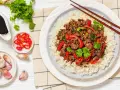 Delicioso arroz con carne picada, pimientos rojos y cilantro fresco. Acompañado de salsa de soja, chiles y ajos.