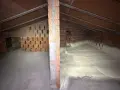 Sottotetto in costruzione con pareti in mattoni e tetto in legno. La lana di roccia a cosa serve? Qui si vede l'isolamento termico e acustico.
