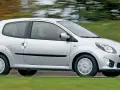 Srebrne Renault Twingo 2 w ruchu, z rozmytym tłem zieleni i drzew.