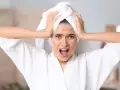 Verzweifelte Frau mit Pickeln im Gesicht, die ihre Hände an den Kopf legt. Sie leidet unter oxidativem Stress der Haut.
