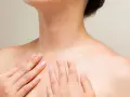 Mains caressant le cou et le décolleté, une invitation à muscler son cou pour une posture élégante.