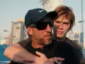 Fernando Vicente, entrenador de tenis, abraza a su pupilo en una cancha con rascacielos de fondo.