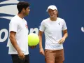 Carlos Alcaraz i Iga Świątek rozmawiają podczas Roland Garros 2024. Carlos trzyma wielką piłkę tenisową.