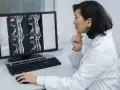 Lekarka analizuje obraz rezonansu magnetycznego kręgosłupa, oceniając szpiczak i jego rokowania.