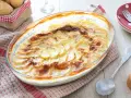 Un gratin dauphinois doré et crémeux, digne d'une recette de Cyril Lignac, prêt à être dégusté.