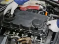 Mechanik w białych rękawiczkach sprawdza silnik. Może to być związane z nieszczelna odma objawy.