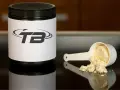 En burk med proteinpulver och en skopa med pulver. Frågan om hur mycket proteinpulver per dag är relevant för att optimera träningen.