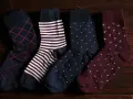 Quattro paia di calzini da uomo con fantasie diverse: rombi, righe, pois. Perfetti da abbinare a un abito elegante.
