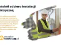 Protokół odbioru instalacji elektrycznej to kluczowy dokument. Na zdjęciu pracownica w kasku i kamizelce odblaskowej sprawdza instalację.