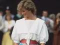 Lady Di sonríe con un conjunto blanco y rojo, un ejemplo de sus icónicos outfits.