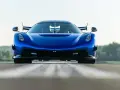 Niebieski Koenigsegg Jesko Attack z agresywnym przednim splitterem i spojlerami, gotowy do ataku na torze.