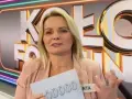 Kobieta z Koła Fortuny trzyma kartę z napisem "00000", zastanawiając się, co daje złota karta w kole fortuny.