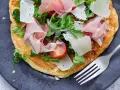 Pyszny przepis na omlet na słono z szynką parmeńską, parmezanem, pomidorkami i rukolą. Idealny na szybki obiad lub kolację.