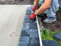 Układanie kostki brukowej na podsypce piaskowej to kluczowy etap, by wiedzieć, na czym postawić garaż blaszany.
