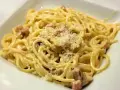 Pyszne spaghetti carbonara z chrupiącym boczkiem, kremowym sosem i parmezanem. Idealne danie dla miłośników włoskiej kuchni.