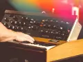 Hand spielt auf einem legendären Minimoog-Synthesizer, der den unverwechselbaren Sound der 70er Jahre prägte.