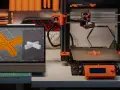 Drukarka 3D drukuje element, a na ekranie tabletu widać model. To ilustracja najczęstszych problemów z drukiem 3d.