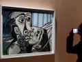 Un visitante captura con su móvil uno de los icónicos cuadros de Picasso, un beso en blanco y negro con toques de azul.