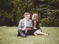 Para młoda siedzi na trawie, czytając razem Biblię. Ich wspólna modlitwa wiernych na ślub jest pełna miłości i nadziei.