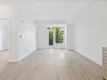 Salón luminoso con suelo de madera clara y puerta acristalada que da a un balcón. Ideal para vender piso heredado antes de 5 años.