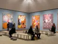 Besökare beundrar Hilma af Klints färgstarka verk i ett galleri. En familj kanske diskuterar konstens mystik.