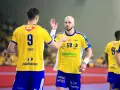 Piłkarze ręczni w żółtych koszulkach z numerami 9 i 50 świętują udany mecz vive.