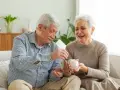 Szczęśliwa para seniorów wrzuca monety do świnki-skarbonki, planując spokojne przejście na emeryturę.