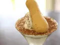 Pyszne tiramisu w kieliszku, posypane kakao, z biszkoptem. Idealne, gdy szukasz, czym zastąpić amaretto.