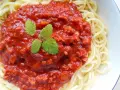 Spaghetti z bogatym sosem bolońskim i listkami mięty.