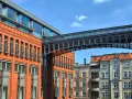 Nowoczesna architektura przeplata się z kamienicami, tworząc ciekawe **ukryte miejsca w Poznaniu**. Metalowy mostek łączy budynki.