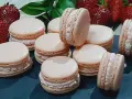 Delikatne makaroniki na mące migdałowej lub kokosowej, z kremowym nadzieniem i świeżymi truskawkami w tle.