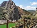 Impresionante paisaje de un parque protegido con imponentes rocas, vegetación frondosa y un río de aguas verdes.
