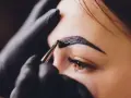 Stylist aplikuje hennę na brwi. Zastanawiasz się, ile kosztuje henna?