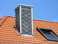 Schornstein verkleiden innen mit Schieferplatten. Dachziegel und Dachfenster sind zu sehen.